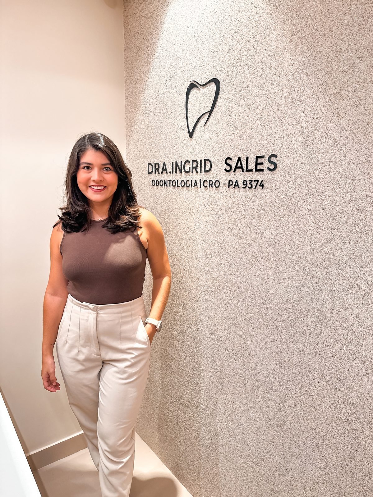 Dra. Ingrid Sales ao lado do logotipo do consultório